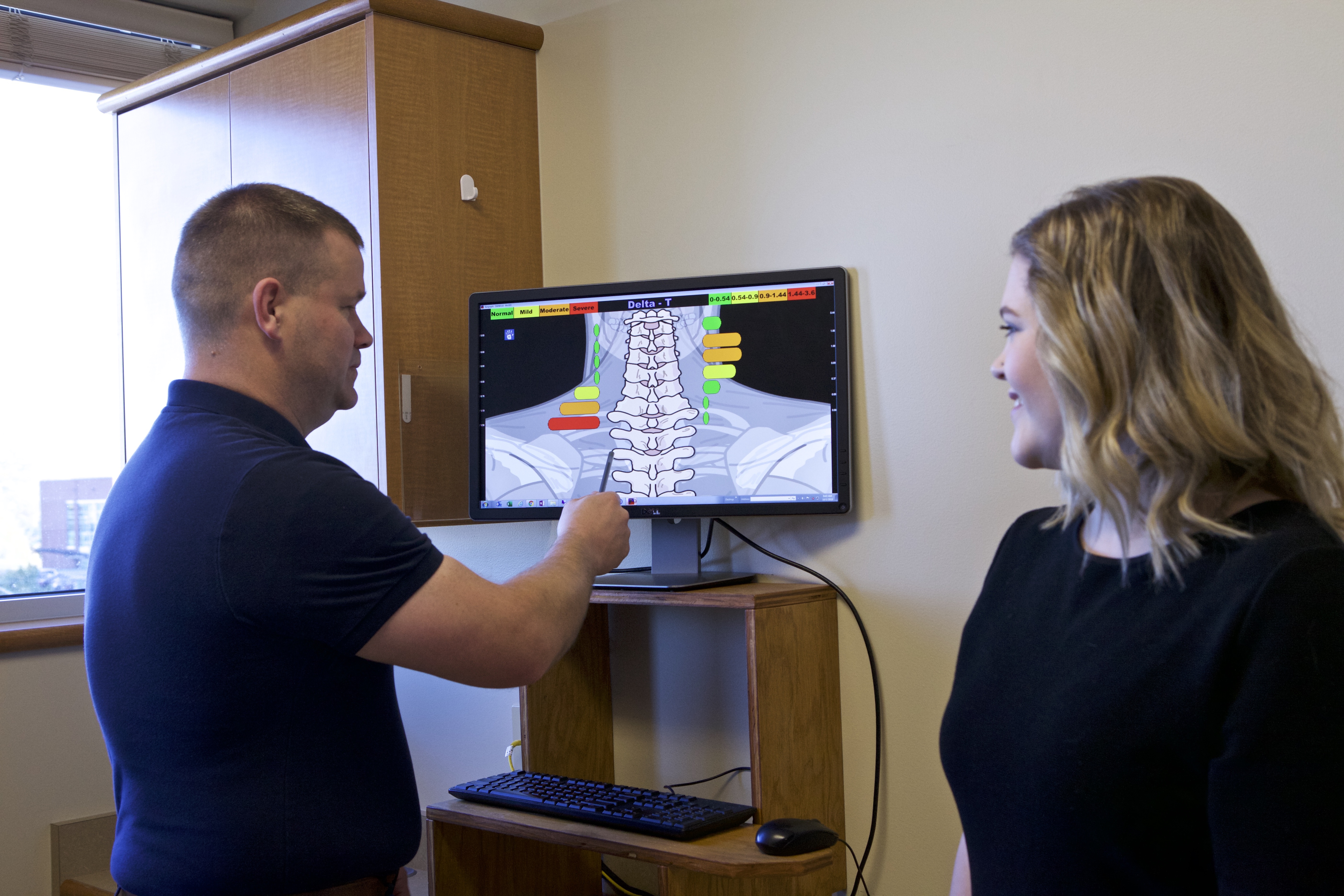 Dr. Croxford reviewing a cervical spine scan with a patient in the exam room